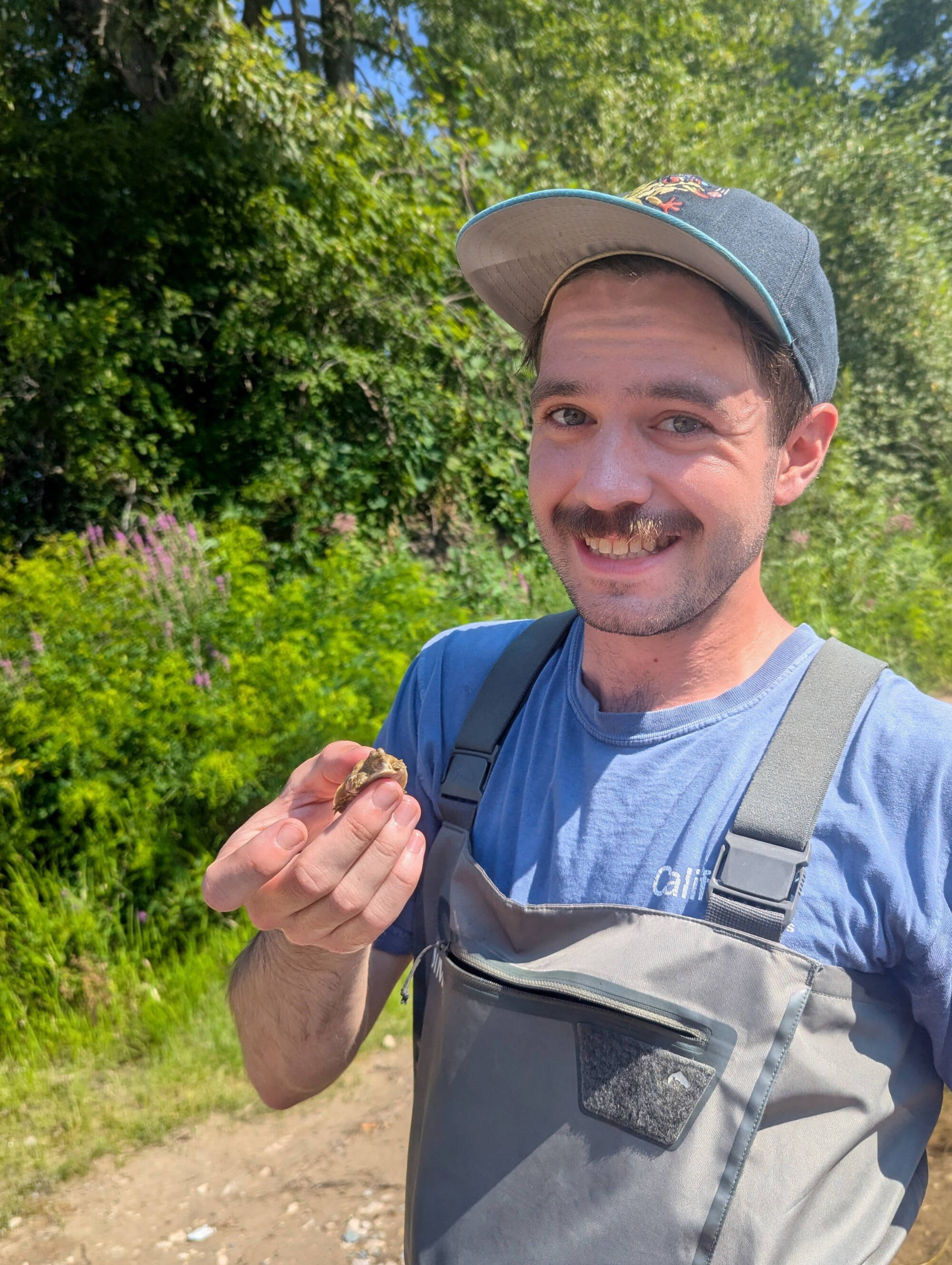 Elliot Hoinville holds a baby turtle for the camera.